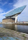 Antwerp Port headquarters against a blue sky with dramatic clouds.