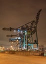 Massive cranes at container terminal at nighttime. The Port of Antwerp in Flanders, Belgium