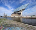 Antwerp Port headquarters against a blue sky with dramatic clouds.