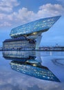 Antwerp Port headquarters at twilight with dramatic clouds, reflected in a pond, Belgium