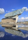 Famous Port of Antwerp Headquarters reflected in a pond on a sunny day, Belgium