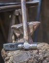 Anvil, hammer and mace displayed over cork oak stump