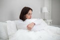 Lonely upset young woman sitting alone in bed