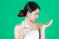 Anxiety stressed young Asian woman holding pills on hands over green isolated background. Medicine and health care concept Royalty Free Stock Photo