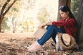 Anxiety woman about her studying sitting lonely under the big tree on park Royalty Free Stock Photo