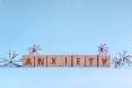 Anxiety word in wooden blocks on blue background. Coping with anxiety, stress, ptsd and depression during covid-19 pandemic Royalty Free Stock Photo