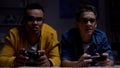 Anxious african-american and caucasian guys playing video game, procrastinators