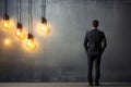 Anxious businessman, back turned, contemplates near lamp against concrete wall