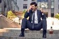 Anxious businessman sitting in steps. Stressed businessman headache and look down with depress feeling. Business problems, Fired,