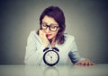 Anxious businesswoman looking nervously at alarm clock Royalty Free Stock Photo