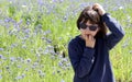 Anxious child with sunglasses having worries over cornflower field, outdoor