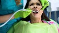 Anxious female sitting in dentistry chair after procedure of caries removal Royalty Free Stock Photo