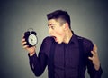 Anxious man looking at alarm clock. Time pressure concept Royalty Free Stock Photo