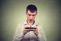 Anxious shocked young man looking at phone seeing bad news Royalty Free Stock Photo