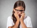 Anxious stressed teenager girl with eyeglasses biting fingernails Royalty Free Stock Photo