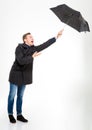 Anxious stressed young man with umbrella flying away