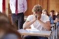Anxious Teenage Student Sitting Examination In School Hall Royalty Free Stock Photo