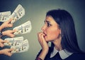 Anxious woman looking at money dollars offered by suspicious people Royalty Free Stock Photo