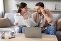 Worried couple reviewing finances with laptop and papers Royalty Free Stock Photo