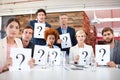 Any questions. Portrait of a group of businesspeople holding up cards with question marks on them.