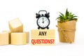 Any questions symbol. Concept words Any questions on wooden blocks on a beautiful white table white background. Black alarm clock Royalty Free Stock Photo