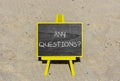 Any questions symbol. Concept words Any questions on black chalk blackboard on a beautiful sand beach background. Business and Any Royalty Free Stock Photo