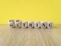 Anything or everything symbol. Turned cubes, changes the concept word Anything to Everything. Beautiful yellow background, wooden Royalty Free Stock Photo