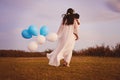 Anything for him. Rearview shot of a young mother and her son walking while holding blue and white balloons outdoors. Royalty Free Stock Photo