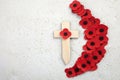 Anzac day. Australian and New Zealand national public holiday or Remembrance day. Red poppies and cross on biege stone Royalty Free Stock Photo