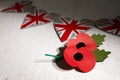 Anzac day. Australian and New Zealand national public holiday or Remembrance day. Red poppy on biege stone background Royalty Free Stock Photo