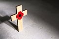 Anzac day. Australian and New Zealand national public holiday or Remembrance day. Red poppy and cross on biege stone Royalty Free Stock Photo