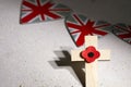 Anzac day. Australian and New Zealand national public holiday or Remembrance day. Red poppy and cross on biege stone Royalty Free Stock Photo