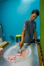 AO NANG, THAILAND - FEBRUARY 19, 2018: Unidentified man working on stir-fried ice cream rolls at freeze pan, man made