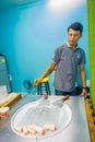 AO NANG, THAILAND - FEBRUARY 19, 2018: Unidentified man working on stir-fried ice cream rolls at freeze pan, man made