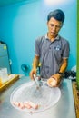 AO NANG, THAILAND - FEBRUARY 19, 2018: Unidentified man working on stir-fried ice cream rolls at freeze pan, man made