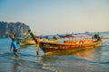 AO NANG, THAILAND - MARCH 05, 2018: Outdoor view of unidentified man in the beach close to Fishing thai boats at Po-da