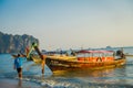 AO NANG, THAILAND - MARCH 05, 2018: Outdoor view of unidentified man in the beach close to Fishing thai boats at Po-da