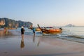 AO NANG, THAILAND - MARCH 05, 2018: Outdoor view of unidentified people walking in the beach close to Fishing thai boats