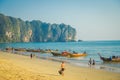 AO NANG, THAILAND - MARCH 05, 2018: Unidentified people walking in the beach close to Fishing thai boats at Po-da island