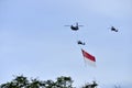 Apache helicopter flying a giant Singapore in the sky Royalty Free Stock Photo