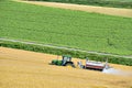 Apanese farmer drive Agriculture Motor Tractor for watering Crop Field in Summer at Biei Patchwork Road, Biei Town, Hokkaido,