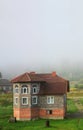 The apartment building is in front of a thick layer of fog. Living in a mountainous area in the Carpathians, Ukraine Royalty Free Stock Photo
