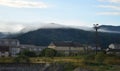 The apartment building is in front of a thick layer of fog. Living in a mountainous area in the Carpathians, Ukraine Royalty Free Stock Photo