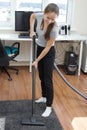 Apartment cleaning.A young European girl vacuuming a room