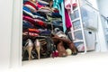 Real apartment closet organized and filled with woman`s clothes, depicting shopping, lifestyle habits, real life and clothing