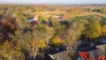 Apartment complex near farm with traditional red barn, tower silos grain bulk storage, farming machine, corn field ready to