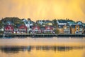 Apartment houses at the waterfront in Ballstad in front of yellow clouds at dawn