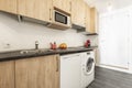 Apartment kitchen with wood cabinets, black countertops, dark tile floors, Royalty Free Stock Photo