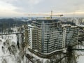 Apartment or office building under construction, aerial view. Tower crane silhouette on blue sky copy space background Royalty Free Stock Photo