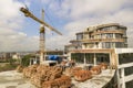 Apartment or office tall building under construction. Brick walls, glass windows, scaffolding and concrete support pillars. Tower Royalty Free Stock Photo